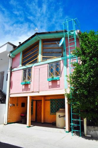 a pink building with a ladder on the side of it at Departamento tipo cabaña en Creel in Creel