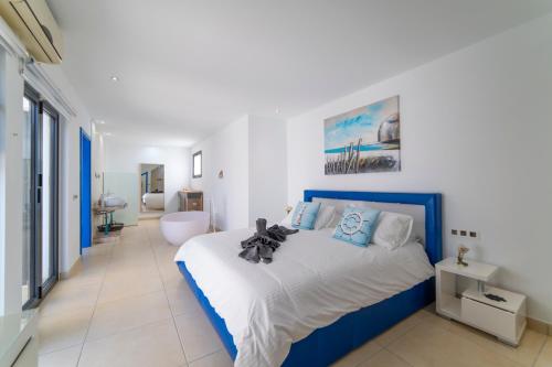 a bedroom with a blue and white bed and a bathroom at Villa Sirmione in Playa Blanca