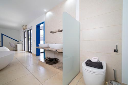 a bathroom with a white toilet and two sinks at Villa Sirmione in Playa Blanca