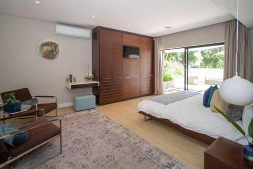 a bedroom with a large bed and a sliding glass door at LIFESTYLE LIVING in Cape Town