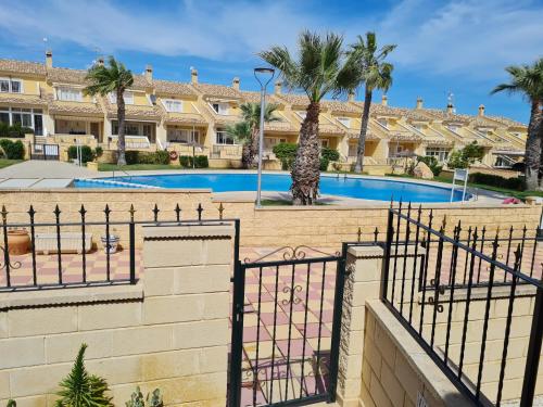 eine Villa mit einem Pool und einem Zaun in der Unterkunft Casa en Punta Prima in Alicante