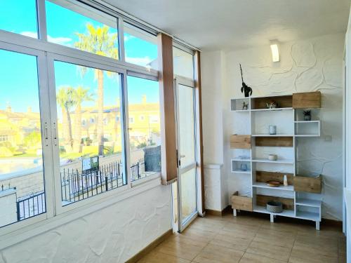 ein Zimmer mit einem großen Fenster und einem Bücherregal in der Unterkunft Casa en Punta Prima in Alicante