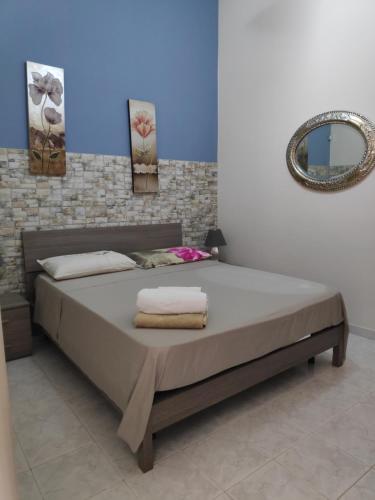 een slaapkamer met een groot bed en een spiegel bij casa G&G in Augusta