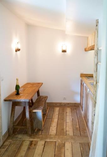 a dining room with a wooden table and bench at Villa Vanille in Boisseron