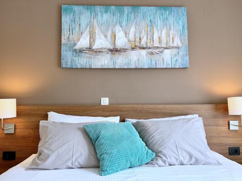 a bed with white pillows and a painting on the wall at Apartments Muntidor in Rab