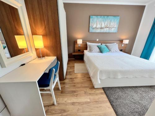 um quarto de hotel com uma cama, uma secretária e uma cama em Apartments Muntidor em Rab