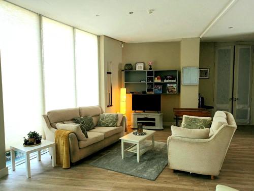 a living room with two couches and a tv at Beautiful 2-Bed Apartment near Waterford City in Waterford