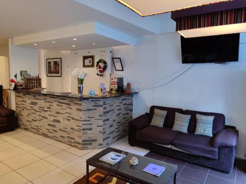 a living room with a couch and a bar at Hostal Premier Inn in Machu Picchu