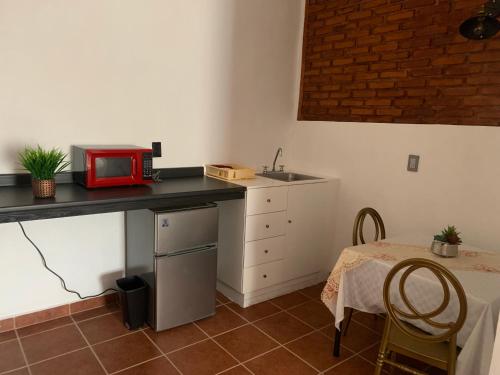een keuken met een aanrecht met een magnetron en een tafel bij Hotel Boutique Casona Mashei in Tasquillo