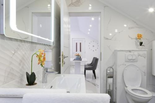 a white bathroom with a toilet and a sink at Luxury Apartment Megy in Otočac