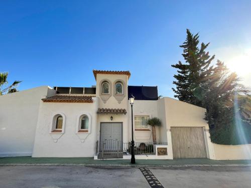 una casa blanca con una puerta y un árbol en Casa Blanca, en Alicante