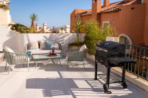 a barbecue grill on a patio with a couch at Casa Blanca in Alicante
