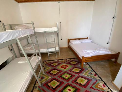 a room with two bunk beds and a rug at Vintage Mediterranean house in Himare