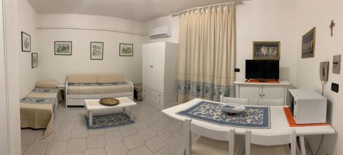 a room with a bedroom with a bed and a table at APPARTAMENTO LIDO 2 in Alghero