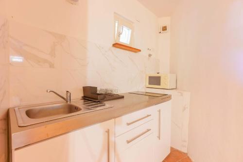a kitchen with a sink and a microwave at B&B Villa Zola in Capoterra