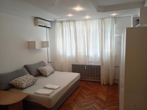 a living room with a couch in front of a window at Apartman Selska in Zagreb