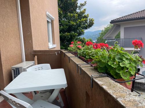 a white table and chairs on a balcony with flowers at Ranco Lake Sunshine Apartment in Ranco