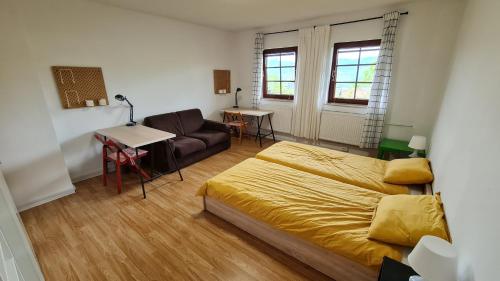 a bedroom with a bed and a couch and a table at Apartma pri babici in Slovenj Gradec
