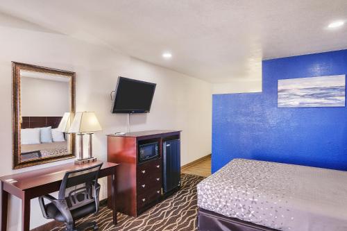 a hotel room with a bed and a desk with a computer at Carlsbad Inn , New Mexico in Carlsbad