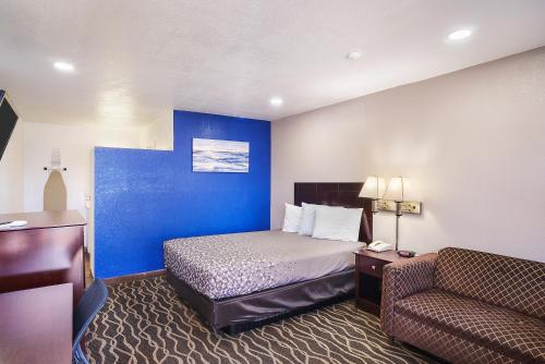 a small hotel room with a bed and a couch at Carlsbad Inn , New Mexico in Carlsbad