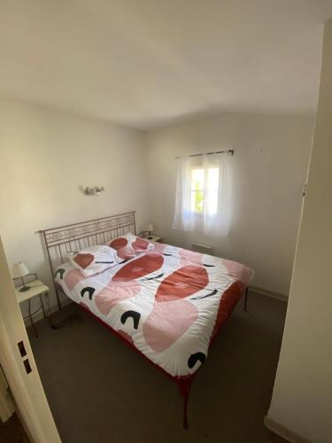 een slaapkamer met een bed met een rood en wit dekbed bij Chez Delphine et Mathieu in Gallargues-Le-Montueux