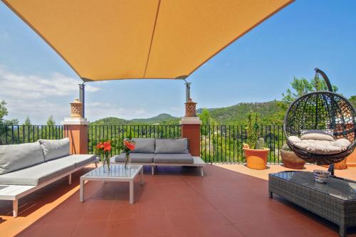 an outdoor patio with a couch and a swing at Finca Sa Fuente in Felanitx