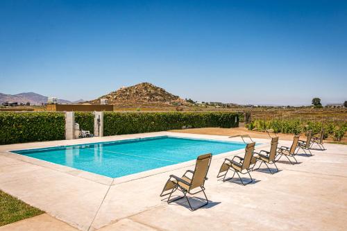 una piscina con sillas y una piscina en Finca San Sebastian, en Valle de Guadalupe