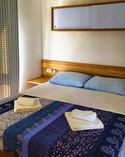 a bedroom with a bed with two towels on it at Mobile Homes Aurea Maris - Kamp Dole Živogošće in Živogošće