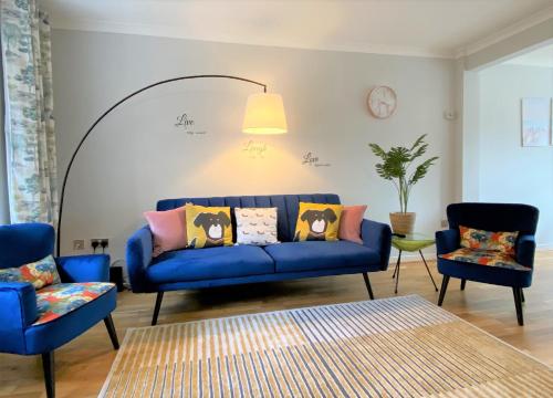 a living room with a blue couch and two chairs at Redhill Town Centre 3 bed House near Gatwick Airport, easy commute to London in Redhill