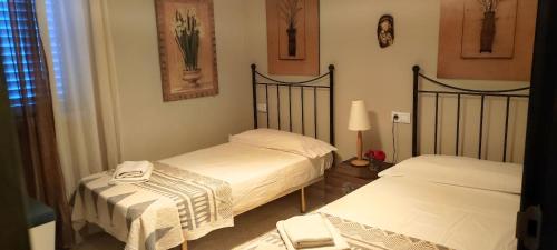 エル・プエルト・デ・サンタマリアにあるMis Tres Centenariosのベッドルーム(ベッド2台、ランプ付)