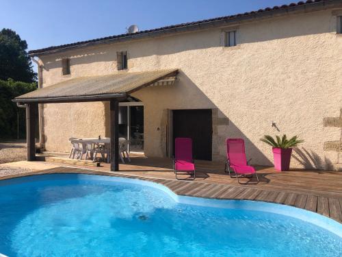une piscine avec des chaises et une table et une maison dans l'établissement Domaine Shanti Lande, à Ménesplet