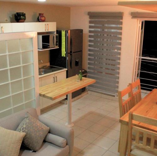 a kitchen with a wooden table and a dining room at San Juan Apartament in Uruapan del Progreso