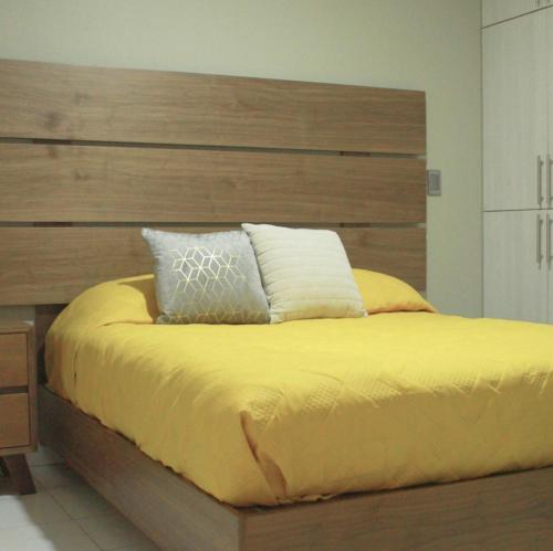1 dormitorio con 1 cama grande y cabecero de madera en San Juan Apartament en Uruapan del Progreso