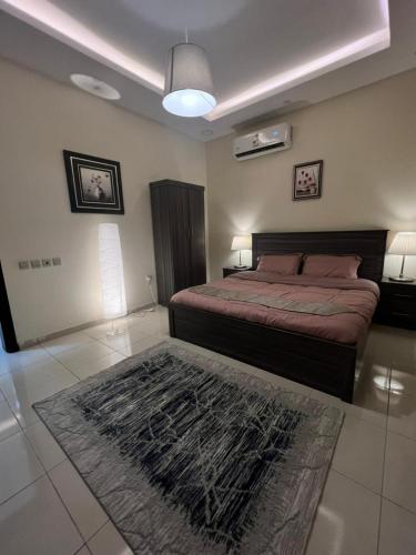 a bedroom with a bed and a rug on the floor at الدمام حي مدينة العمال الشارع العاشر in Dammam