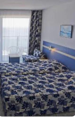 a bedroom with a bed with a blue and white comforter at Къща за гости in Pleven