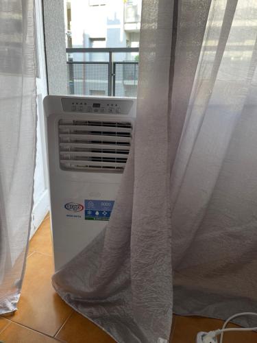 a air conditioner sitting next to a window with curtains at Къща за гости in Pleven