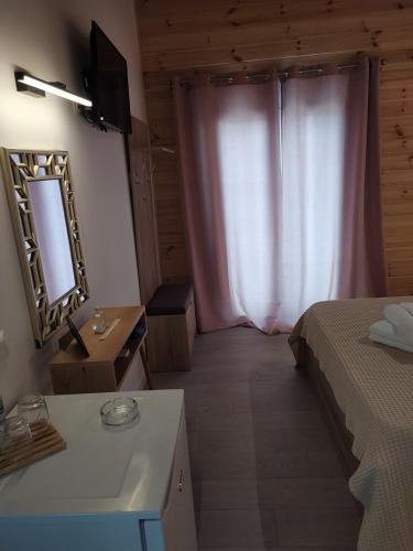 a bedroom with a bed and a mirror and a table at Elafonisos Isle B1 in Elafonisos