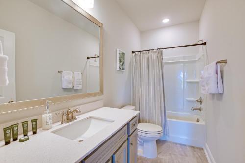 a bathroom with a sink and a toilet and a mirror at North Myrtle Beach Townhome with Pool and Golf Access in Myrtle Beach
