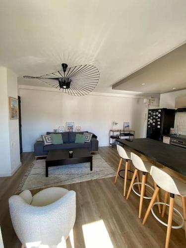 un salon avec un canapé, une table et des chaises dans l'établissement Charmant T2 à proximité de la plage des Catalans, à Marseille