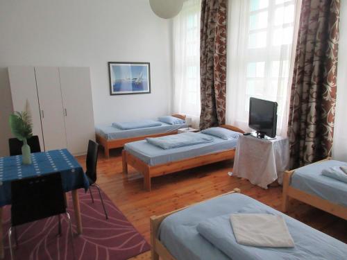 um quarto com três camas e uma tv nele em Villa Deco Parádsasvár em Parádsasvár