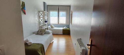 ein kleines Zimmer mit 2 Betten und einem Fenster in der Unterkunft Barosa rooms in Barro