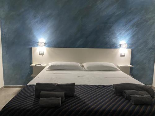 ein Schlafzimmer mit einem großen Bett mit zwei Kissen darauf in der Unterkunft B&B Akoya Capo Vaticano in Capo Vaticano