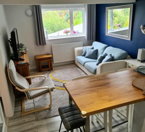 a living room with a couch and a table at Benllech Beach in Benllech