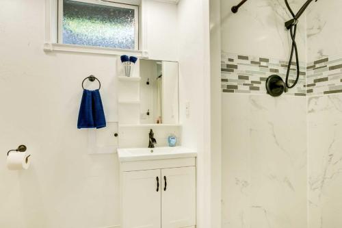 y baño blanco con lavabo y ducha. en Missouri Studio Getaway Close to Parks and Hiking, en Liberty