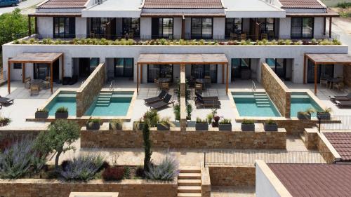 - une vue aérienne sur un bâtiment avec une piscine dans l'établissement Pnoes Luxury Suites, à Paliouri