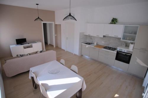 een keuken en een woonkamer met een witte tafel en stoelen bij Casa Vacanza MaGia Pineto in Pineto