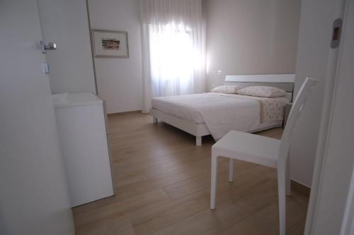 um quarto com uma cama, uma cadeira e uma janela em Casa Vacanza MaGia Pineto em Pineto