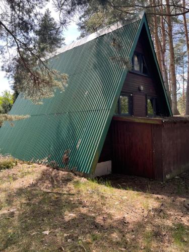 uma pequena casa com um telhado verde em Leśny domek em Koronowo