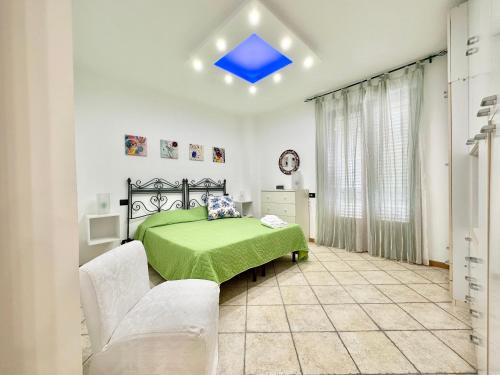 1 dormitorio con 1 cama verde y 2 sillas blancas en Normanni 28 - Private and Guest House, en Campagna
