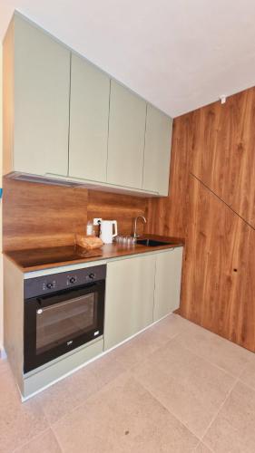 a kitchen with white cabinets and a sink and a stove at Apartment Villa for 6 person with garden in Golem